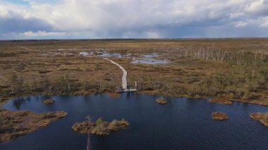 İnsansız hava aracı Yelnya bataklıklarını, gölleri ve orman adalarını ele geçirir. Tahta bir sahil yürüyüşü dramatik bulutlu bir gökyüzünün altında....