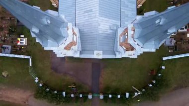 İnsansız hava aracı ahşap kapılardan yükselerek kırmızı tuğlalı bir Katolik kilisesini ve Gotik ve Neo Gotik mimarisini gözler önüne seriyor..