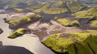 İnsansız hava aracı yeşil yosun kaplı tepeleri ve karanlık volkanik toprağı olan bir vadiden akan nehirleri yakalıyor ve İzlanda 'nın dramatik arazisini gözler önüne seriyor..