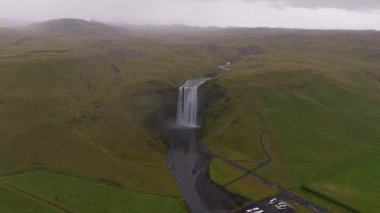 İnsansız hava aracı İzlanda 'daki kayalık kayalıkların üzerinden çağlayan bir şelale yakalıyor. Nehirler ve çevresindeki engebeli araziler görülebiliyor..