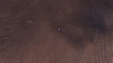 İnsansız hava aracı İzlanda 'da çorak bir volkanik ovaya çıkar, tek bir araç ve zayıf izler ortaya çıkarır, geniş ve ıssız araziyi vurgular..