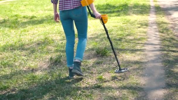 Girl treasure hunter is searching for a metal detector — Stock Video