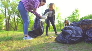 Anne ve genç kızı park kavram plastik torbalarda çöp toplamak