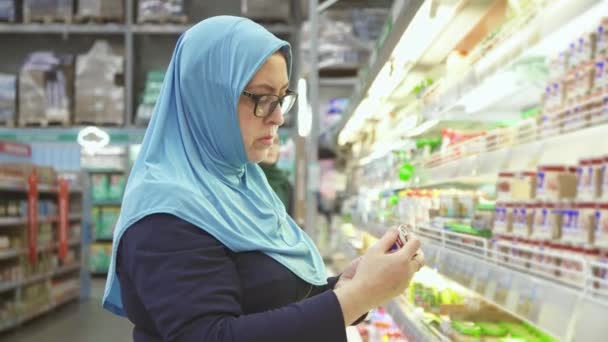 Femme en hijab 40 ans de shopping, choisit la nourriture pour bébé — Video