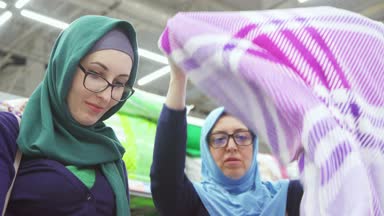 iki güzel Müslüman kadın alışveriş, seçim Tekstil yakın çekim