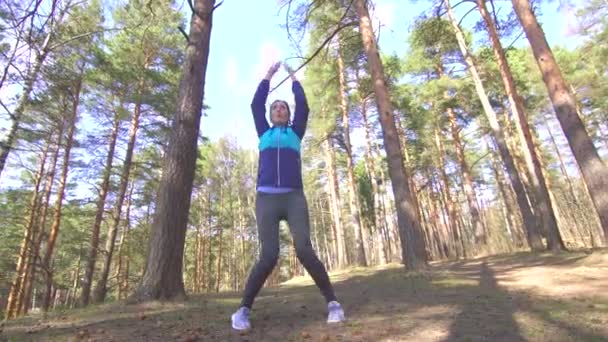 Menina morena faz um treino em uma floresta ensolarada — Vídeo de Stock