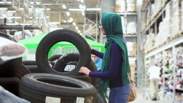 attrayante fille musulmane shopping, choisir un pneu automobile 