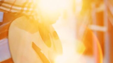 Tanınmayan eller kız gömlek Sokak müzisyeni günbatımında gitar çalmak