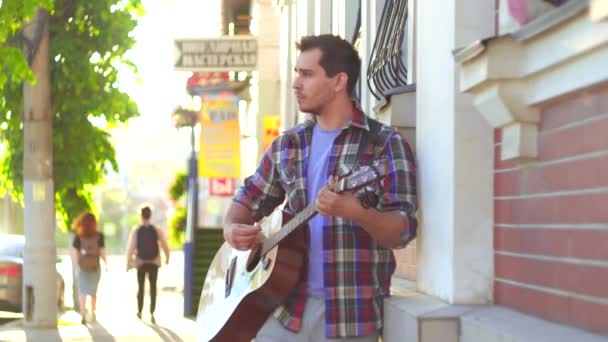 Maschio musicista di strada in camicia suonare la chitarra in città — Video Stock