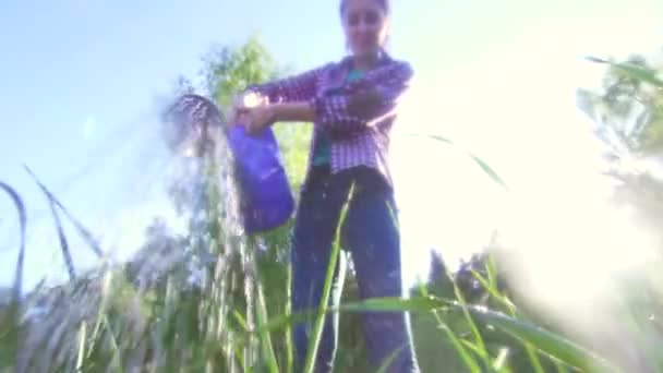 Meisje boer in shirt drenken bedden in slow-mo — Stockvideo