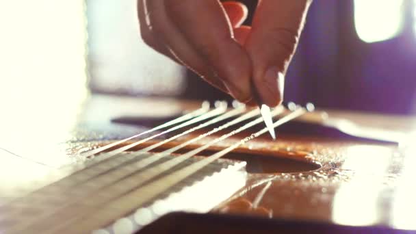 Close-up van gitaar punch plectrum op de snaren in de regen — Stockvideo