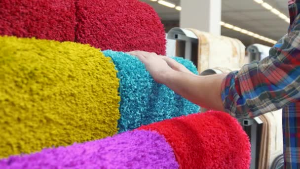 Człowiek wybiera dywan, z bliska — Wideo stockowe