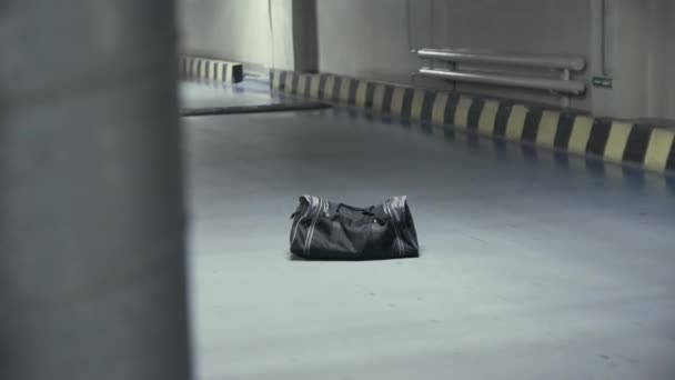 Bolsa negra sospechosa en el aparcamiento subterráneo — Vídeo de stock