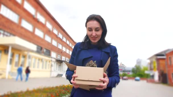 Gimbal shot girl carries a box of abandoned kittens to an animal shelter — Stock Video