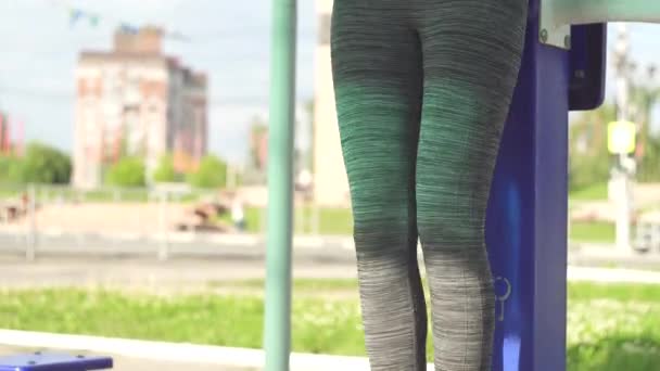 Meisje doet oefeningen op buikspieren outdoor fitnessapparatuur — Stockvideo