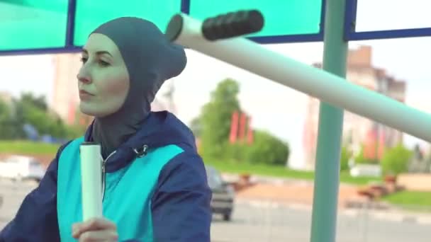 Дівчина в хіджабі в спортзалі на вулиці — стокове відео