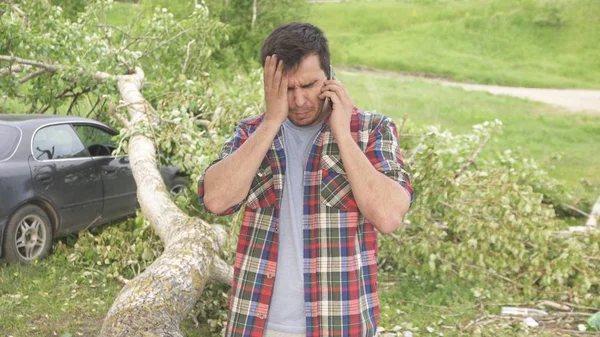 Portrait of a man with a phone, the consequences of a natural disaster — Stock Photo, Image