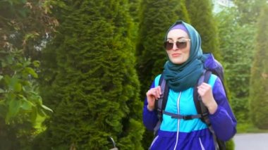 konuşan ve gülen hijab turistik bir sırt çantası içinde gözlük ile güzel bir Müslüman kadın portresi kullanır