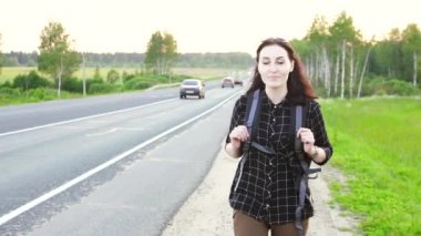 otostopçu kız yolda yürürken bir turist sırt çantası ile