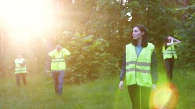 yeşil yelek gönüllü, ormanda, günbatımında eksik arama çalışmalarını