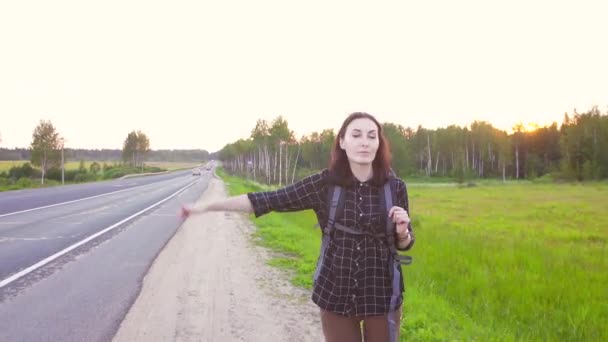 Turystyczna dziewczynka z plecakiem na autostradzie, koni do jazdy, kciuk w górę — Wideo stockowe