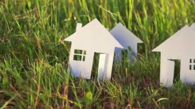 Kağıt yeşil çim zemin üzerine yapılmış birden fazla karton ev