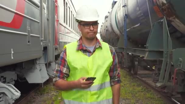 Портрет работника железной дороги, идет к железнодорожному вокзалу — стоковое видео