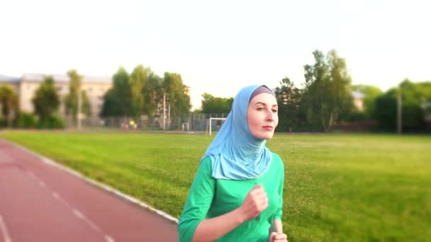 Atractiva chica musulmana deportiva en hijab en una carrera — Vídeos de Stock