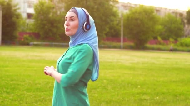 Aantrekkelijke sportieve moslim meisje in hijab opwarmt — Stockvideo