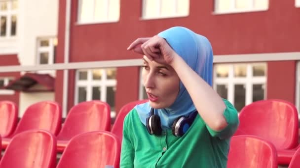 ヒジャーブ飲料水のトレーニングの後に魅力的なスポーティなイスラム教徒の少女 — ストック動画