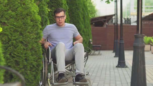 Młody człowiek na wózku inwalidzkim, próbując wstać — Wideo stockowe