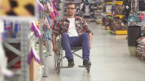 A a fogyatékosság viselt a kerekesszékben, a bevásárlóközpontban egy ember portréja — Stock videók