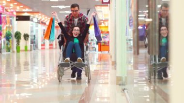 Engelli bir kadın eğleniyor, Mall.Theyre, tekerlekli sandalyede alışveriş sonra şanslı biri onlar gülüyor. Yavaş mo