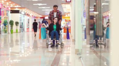 Engelli bir kadın eğleniyor, Mall.Theyre, tekerlekli sandalyede alışveriş sonra şanslı biri onlar gülüyor.