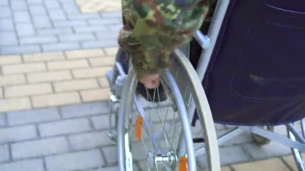 Närbild av soldat med funktionsnedsättning rör sig i rullstol raster — Stockvideo