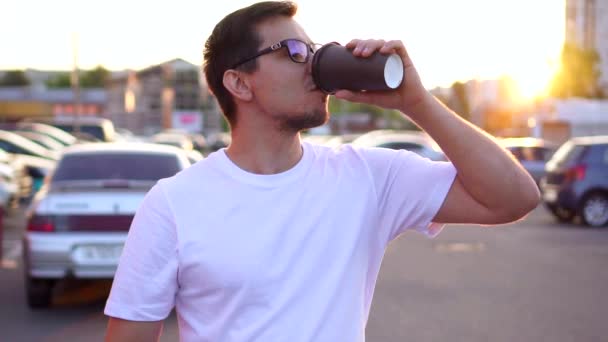 Ein junger Mann mit Kaffee in der Hand geht morgens zur Arbeit. — Stockvideo