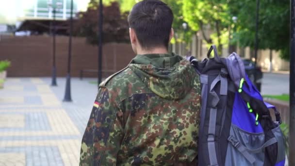 彼の肩にバッグを持った兵士の肖像画。裏からの眺め。遅い mo — ストック動画