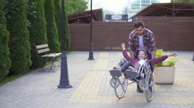 Parkta tekerlekli sandalyede mutlu bir genç adam rulo