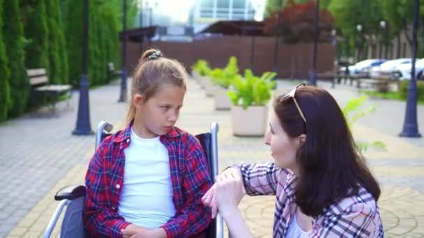 Teenager behindert im Rollstuhl im Gespräch mit einem Mädchen