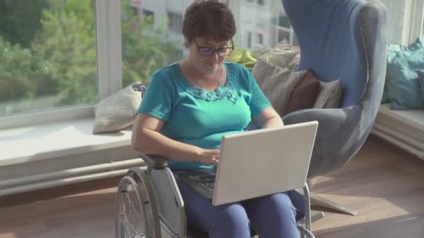 Empresária em cadeira de rodas trabalhando no laptop em casa. — Vídeo de Stock