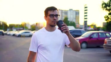 Genç bir adam elinde kahve ile sabah işe gider