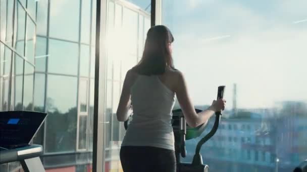 Atraktivní sportovní dívka v stylovém tělocvičně před oknem — Stock video