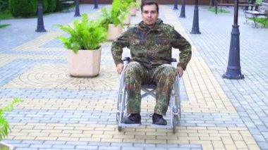 Kamuflaj tekerlekli bir Engelli askeri. Yavaş mo
