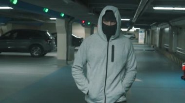 Adam suçlu siyah yün ve hood yürür ve tehditkar bir şekilde etrafına bakıyor. Yavaş mo