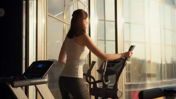 Meisje gaat voor sporten in een stijlvolle fitnessruimte voor het raam — Stockvideo