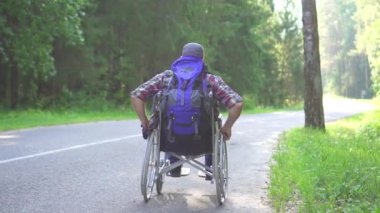 Bir tekerlekli sandalye seyahat Engelli adam karayolu üzerinde sürmek. Yavaş mo