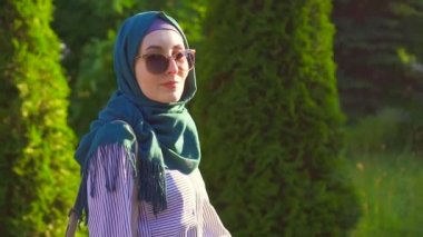 Hijab genç çekici Müslüman kız gider ve kameraya benziyor. Yavaş mo