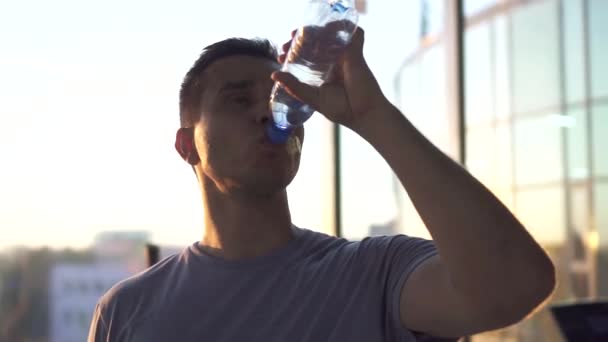 Portrait sports man quenches thirst after training in a stylish gym.Slow mo — Stock Video