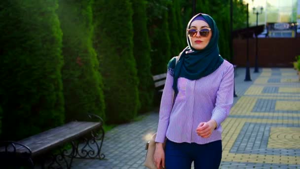 Stílusos muszlim nő a hidzsáb és a szemüveg, a sunflare. Lassú mo — Stock videók