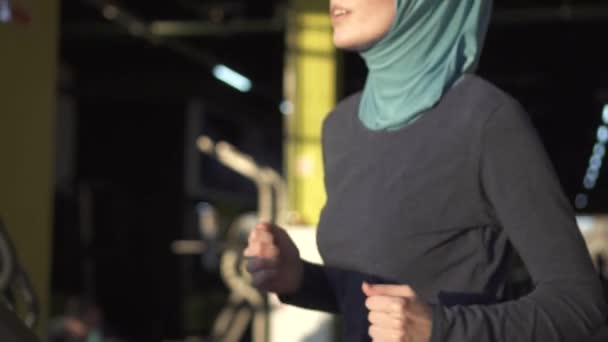 Zár-megjelöl-ból egy sport muszlim nő a hidzsáb-a szimulátor a fitneszteremben. Lassú mo — Stock videók